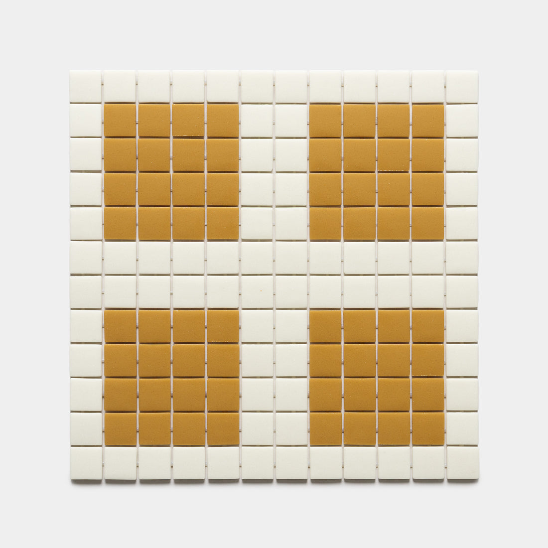 The Ells Milk + Rye sample by Zia Tile features a grid of small white square tiles with four larger orange squares, evenly spaced in a 2x2 pattern.