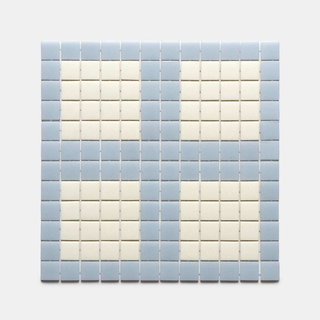 Ells Tranquil Blue + Milk by Zia Tile features a grid of square tiles in pale blue and off-white, arranged in alternating rows and columns for a subtle checkered effect on a light gray background. Sample available.
