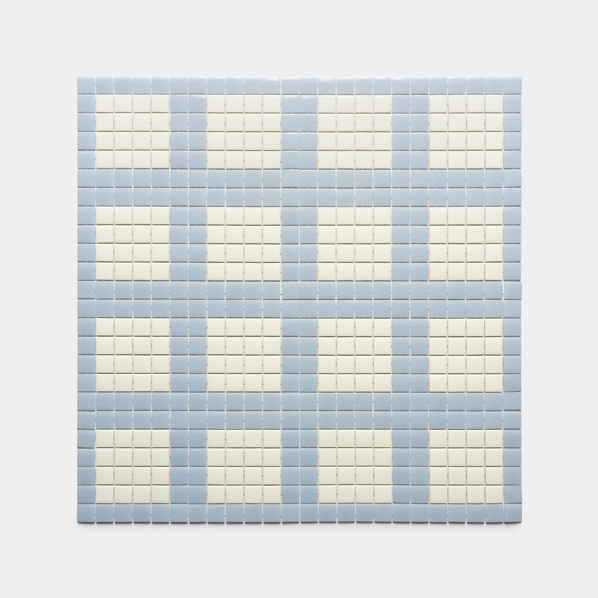 A grid of Zia Tile’s Ells Tranquil Blue + Milk forms a checkered pattern of alternating light blue and off-white squares on a white background.