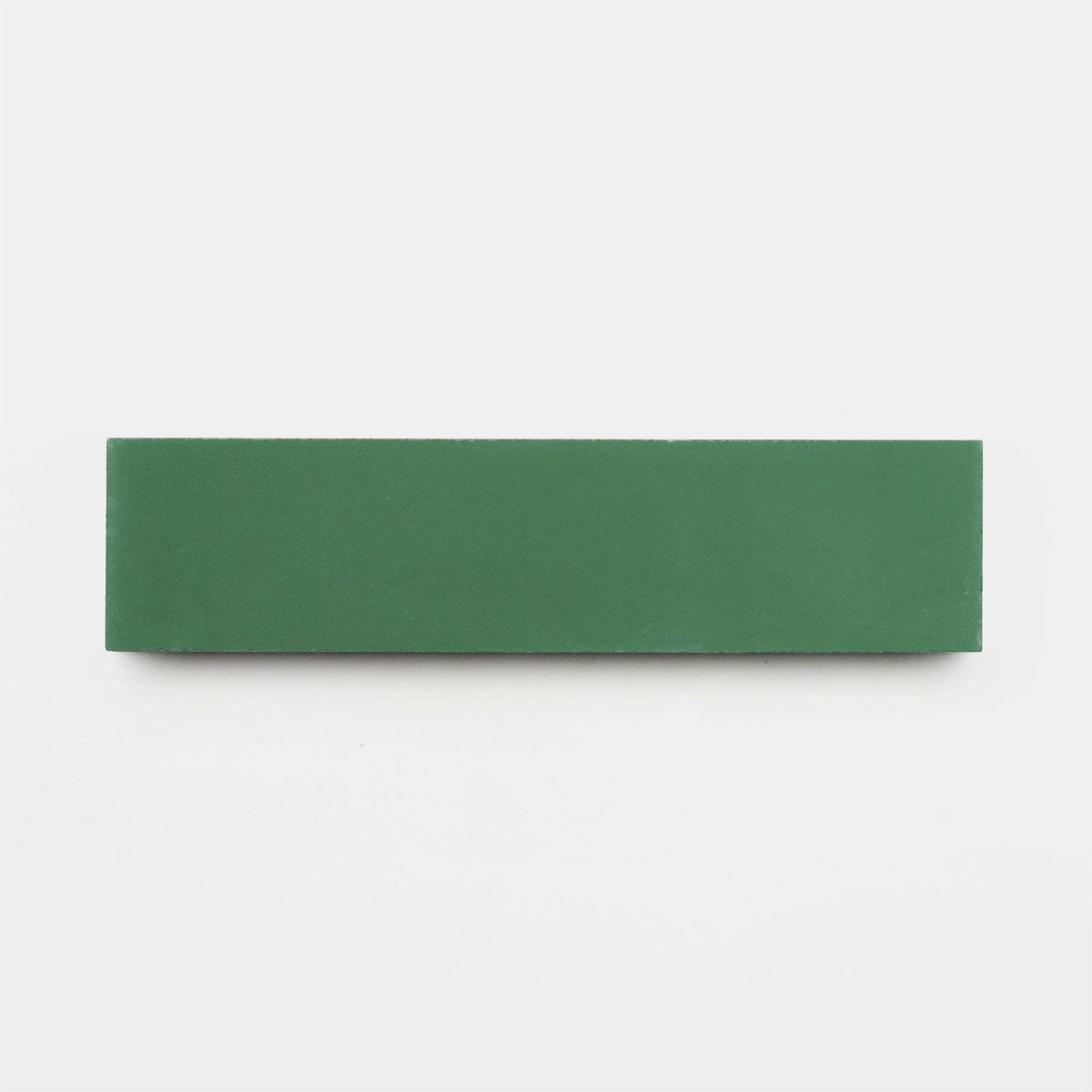 An Emerald 2x8 tile sample from vendor-unknown, featuring a rectangular green design, rests on a plain white background.
