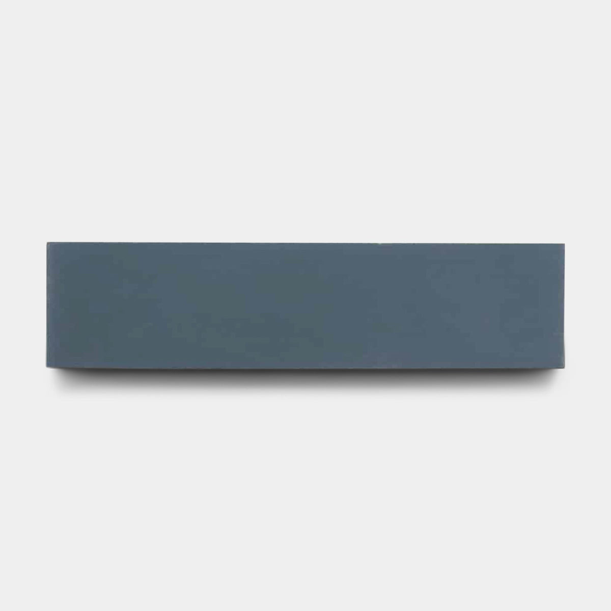 A rectangular Empire Blue 2x8 tile sample by vendor-unknown is centered on a plain light gray background, resembling a handmade tile.