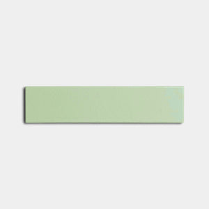 The Eucalyptus 2x8 rectangular light green ceramic tile by Zia Tile, featuring a glossy finish, is centered on a plain white background.