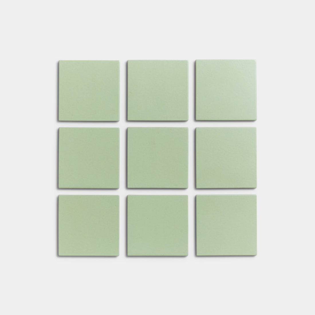 Nine Eucalyptus 4x4 matte ceramic tiles by Zia Tile, in pale green, are arranged in a 3x3 grid on a white background.