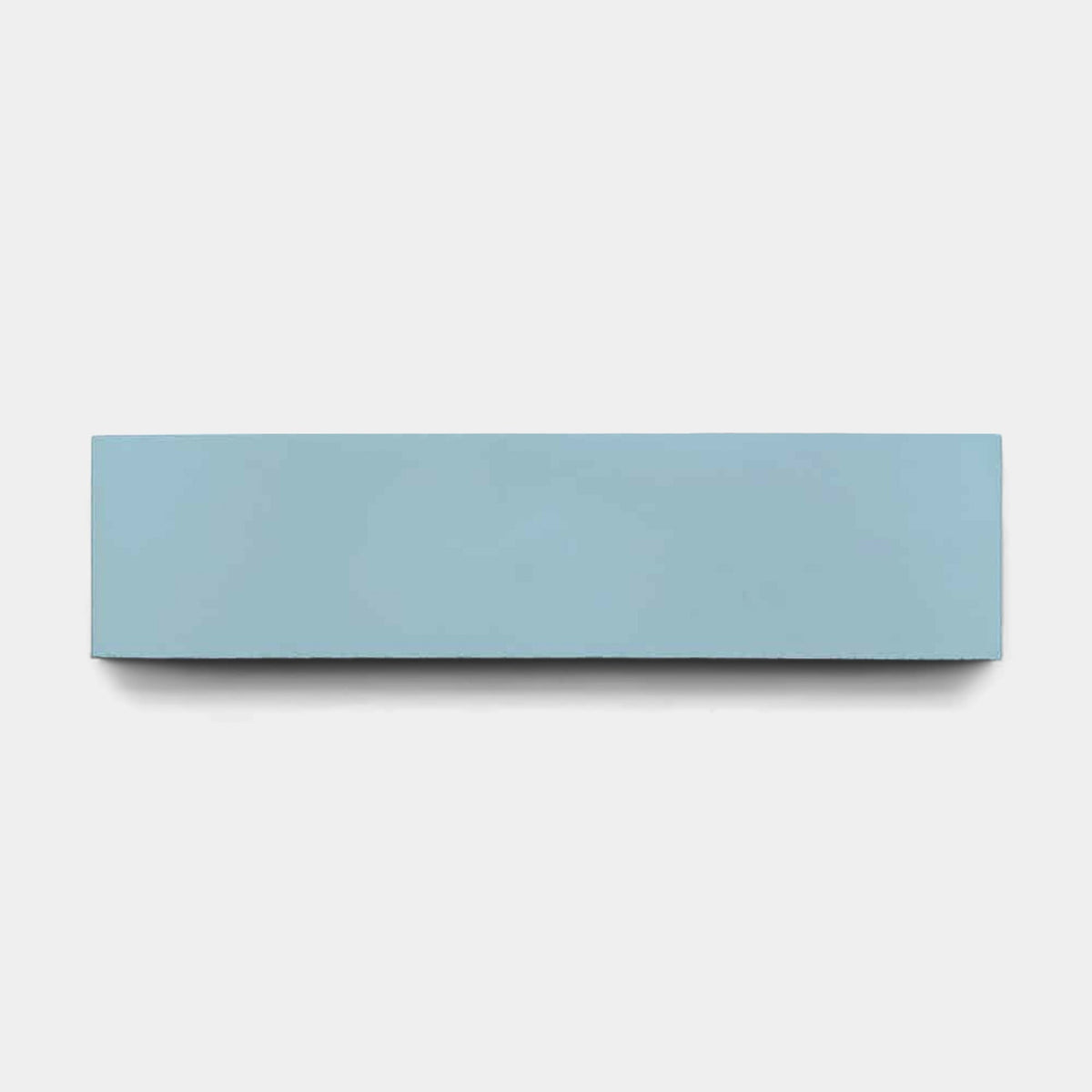 A rectangular, light blue Everest 2x8 tile sample by vendor-unknown is centered on a plain white background, its smooth finish reminiscent of handmade tile.