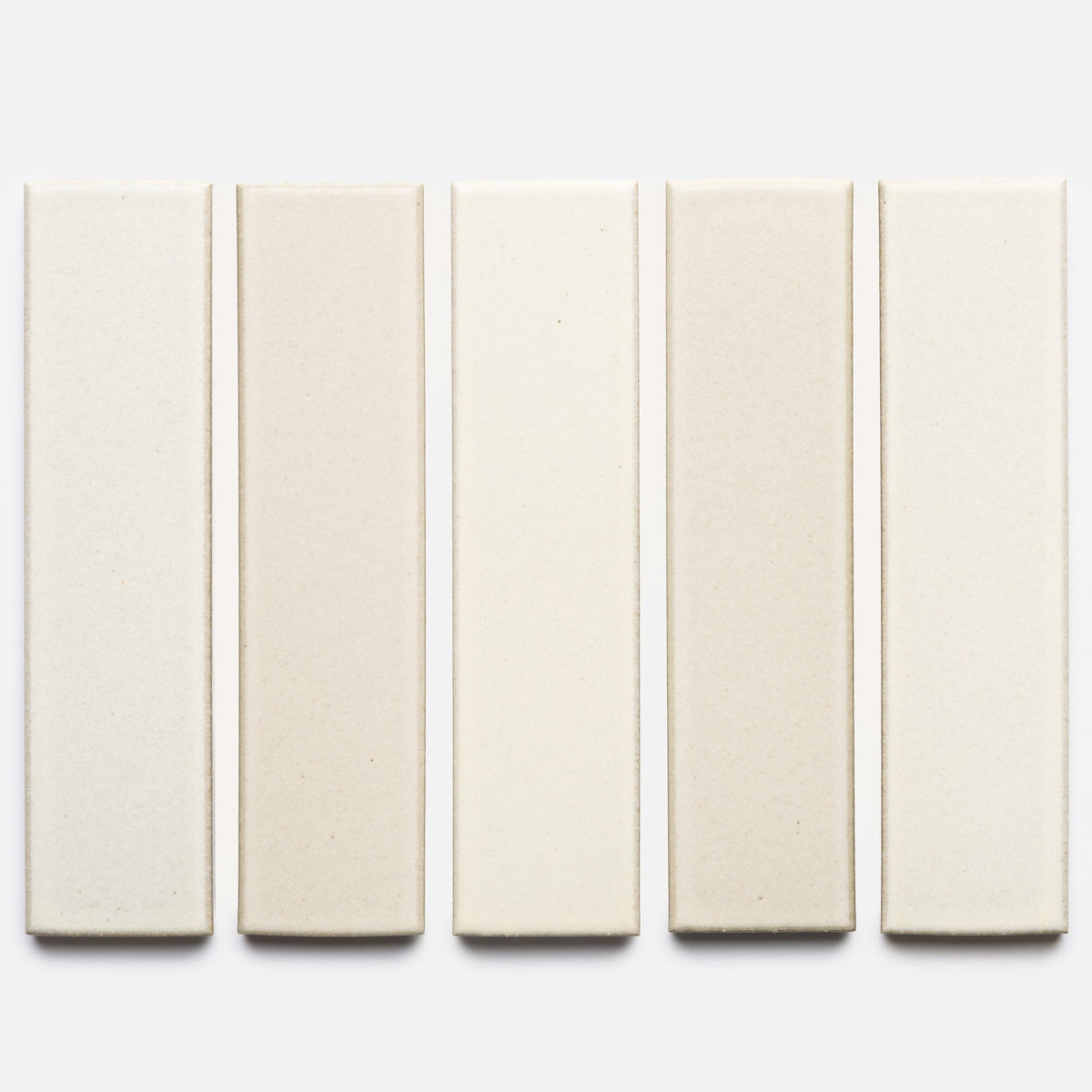 Five rectangular Feather + Flat ceramic tile samples by Zia Tile, in varying off-white and beige shades, arranged vertically against a plain white background.
