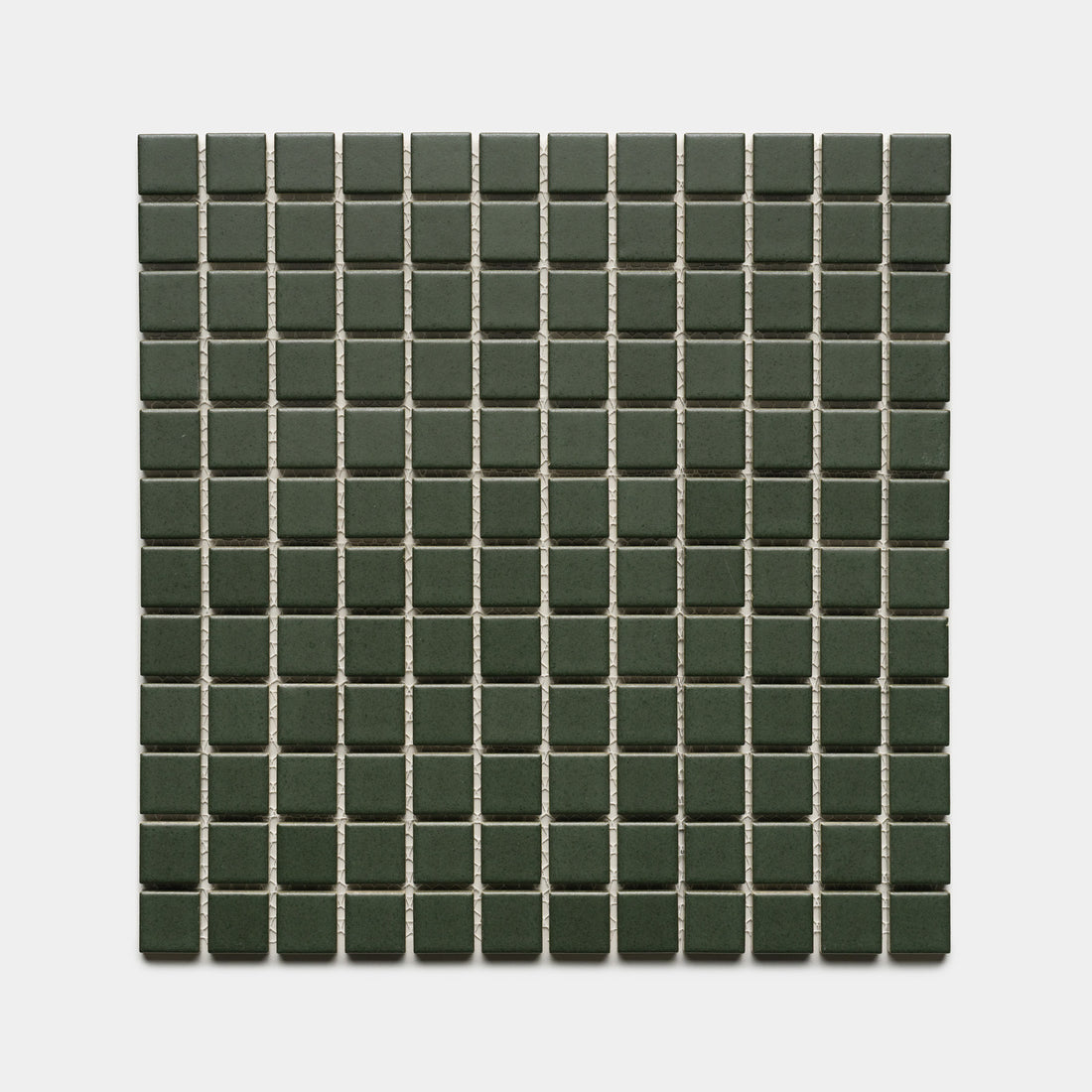 Fraser 1x1 by Zia Tile features small, square dark green tiles with light grout lines, creating a neat and symmetrical pattern on a white background.