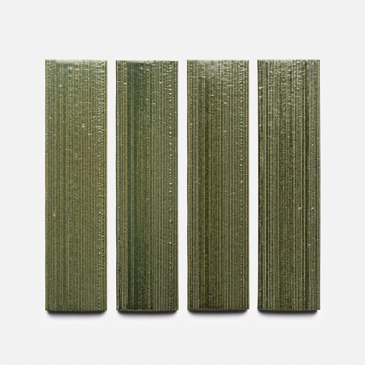 Four green, vertically oriented Frogtown + Etched ceramic tile samples from Zia Tile, featuring a textured ridged surface, are arranged in a row against a plain white background.