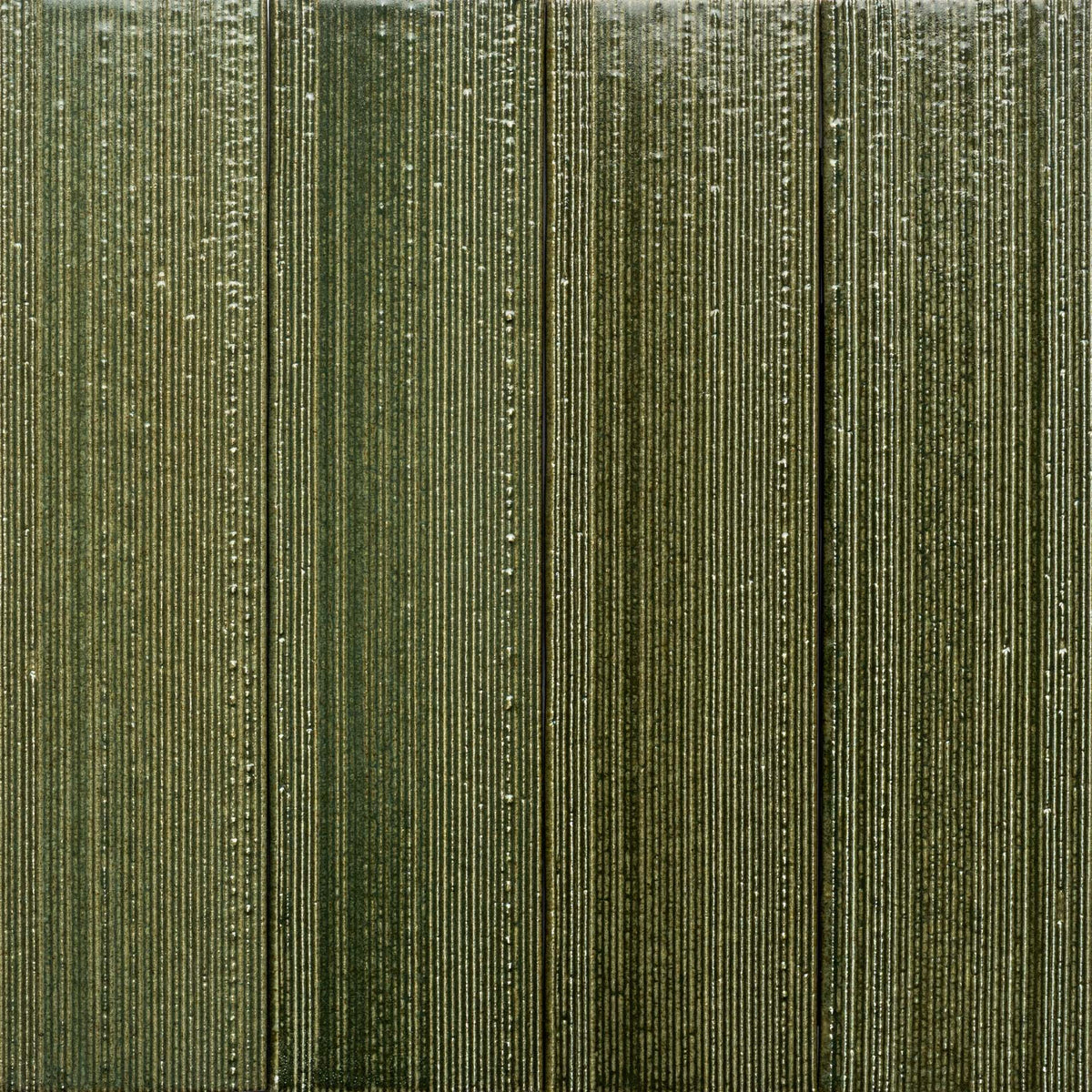 Close-up of Frogtown + Etched, Sample by Zia Tile: a textured green surface with vertical, parallel ridges and lines, subtle sheen, and varying green shades—resembling decorative wall paneling.