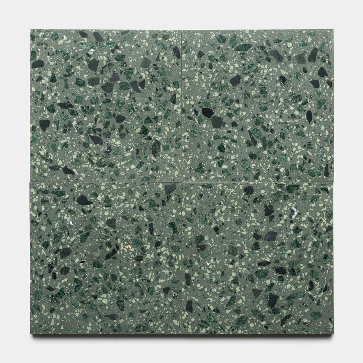 Four Zia Tile Gaia 12x12 terrazzo tiles with a green base and mixed green, black, and white chips, arranged in a square on a plain light gray background.