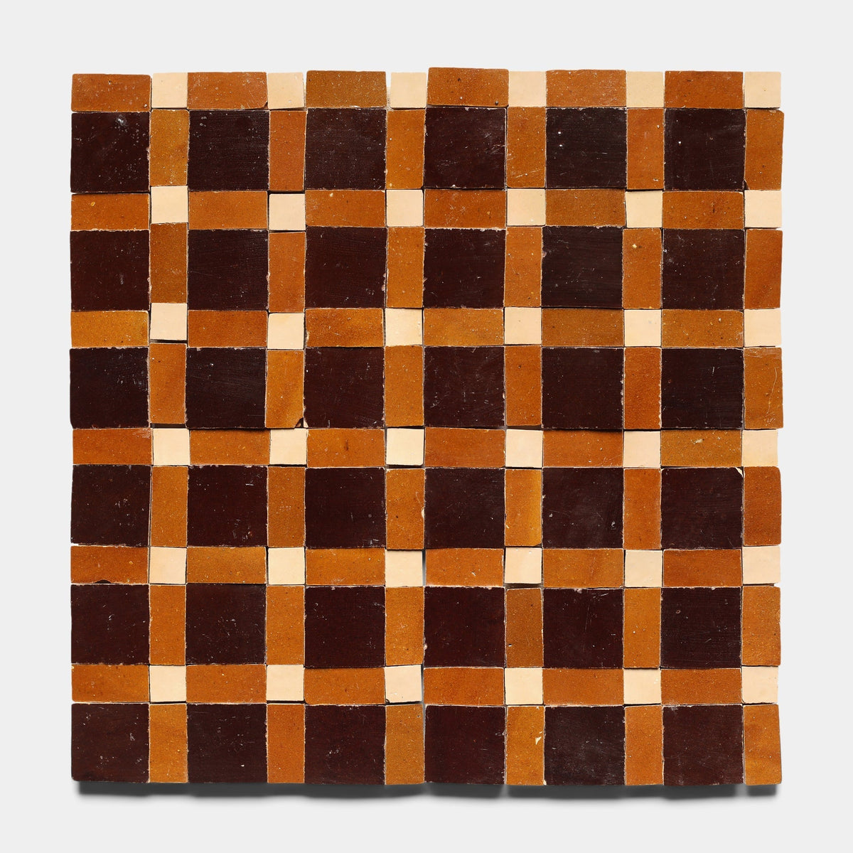 The Gambit 5 sample by Zia Tile features a checkerboard of square tiles in dark brown, burnt orange, and beige—ideal for fans of handmade tile designs.