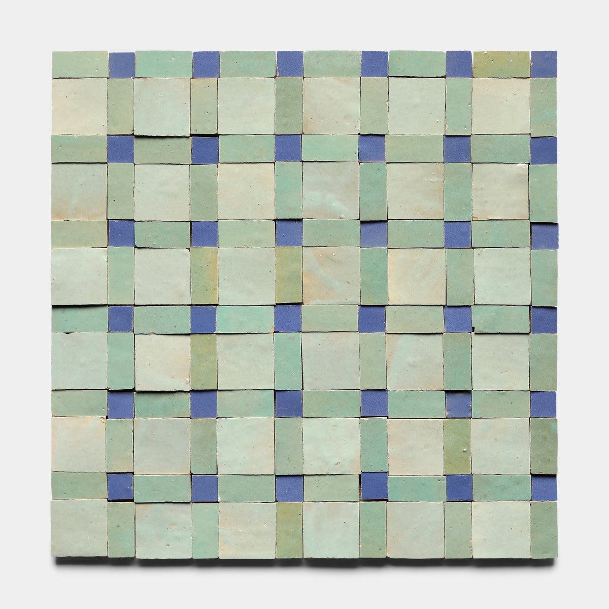 The Gambit 7 Sample by Zia Tile features handmade square tiles in a grid with light green tiles and small blue accent tiles at intersections, forming a subtle checkerboard effect on a white background inspired by classic Zia Tile designs.