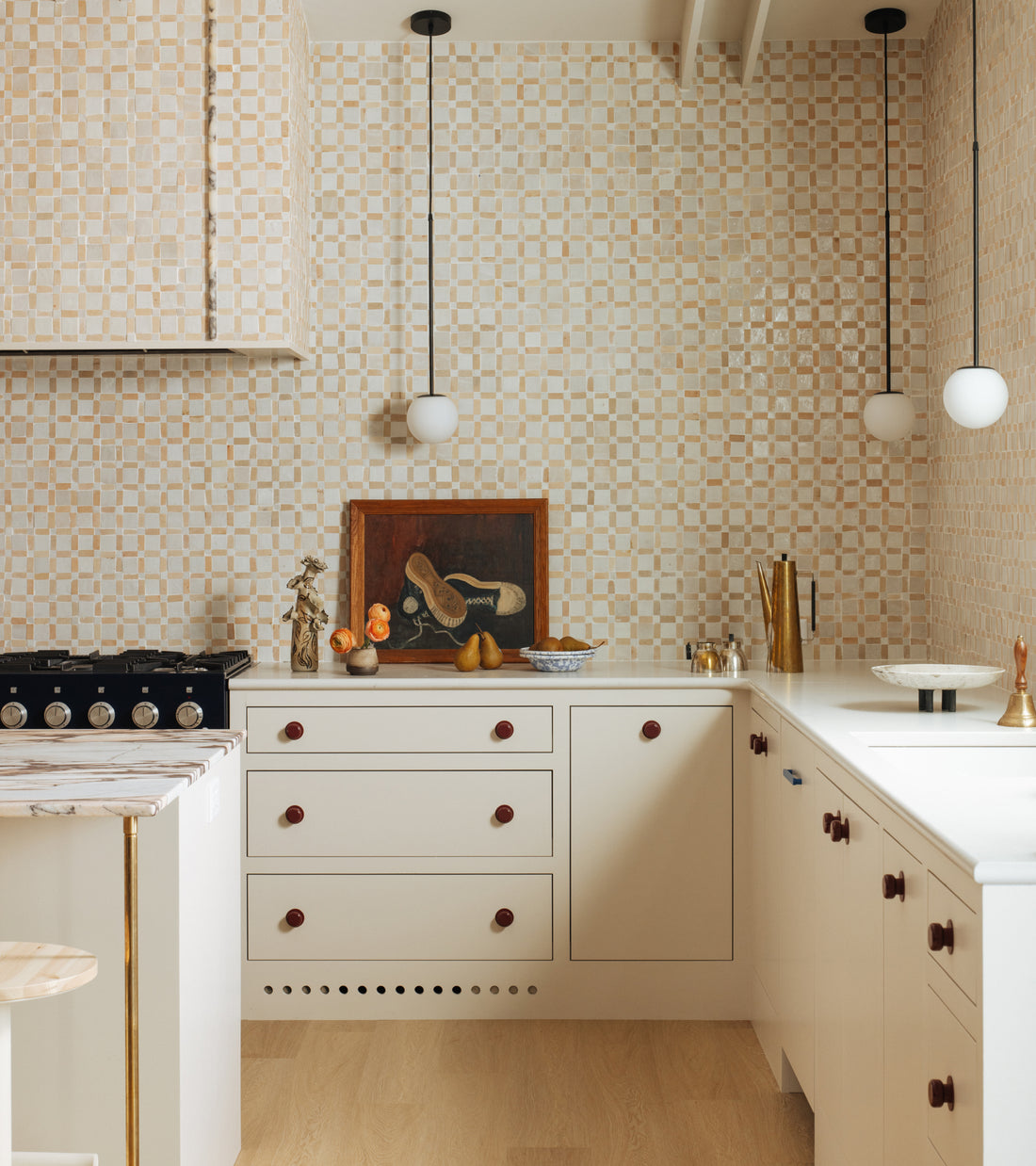 Kitchen with cream cabinets, white countertops, and a backsplash of Zia Tile Gambit 2 mosaic zellige tiles in a small grid pattern.