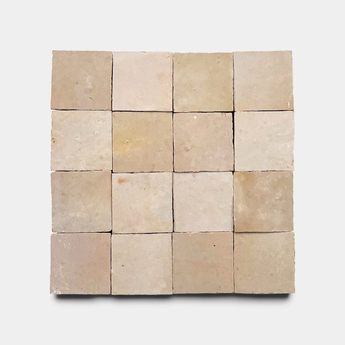 Sixteen square Glazed Earth 2x2 tiles from Zia Tile, arranged in a four-by-four grid on a white background, display a slightly rough handmade texture with natural color variation.