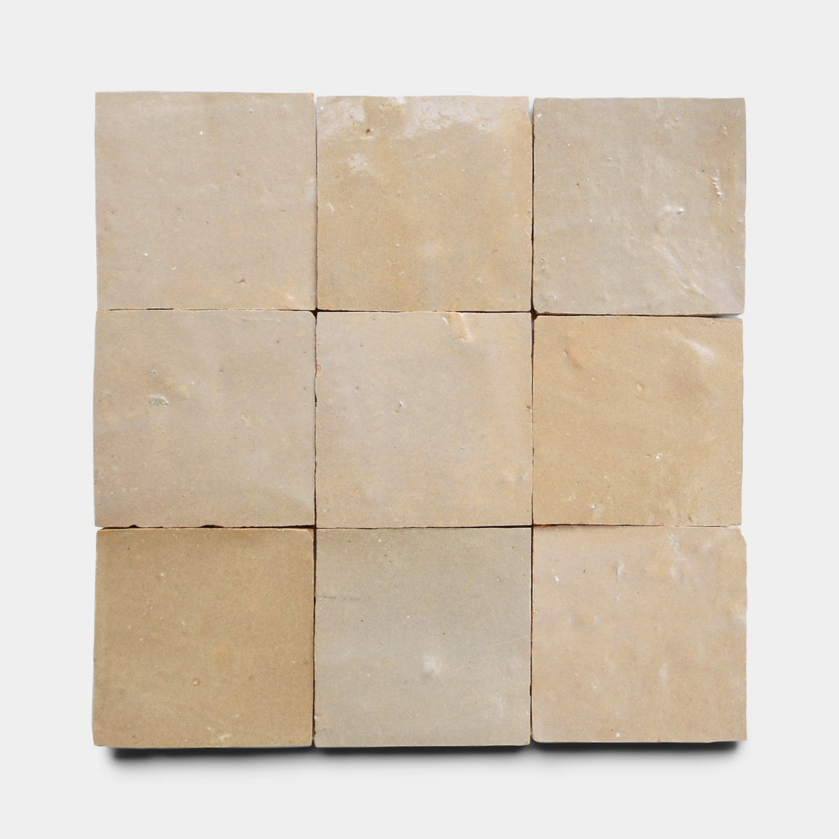 Nine Glazed Earth 2x2 sample tiles from Zia Tile, arranged in a three-by-three grid on white; their matte surfaces are slightly uneven and feature subtle color variations.