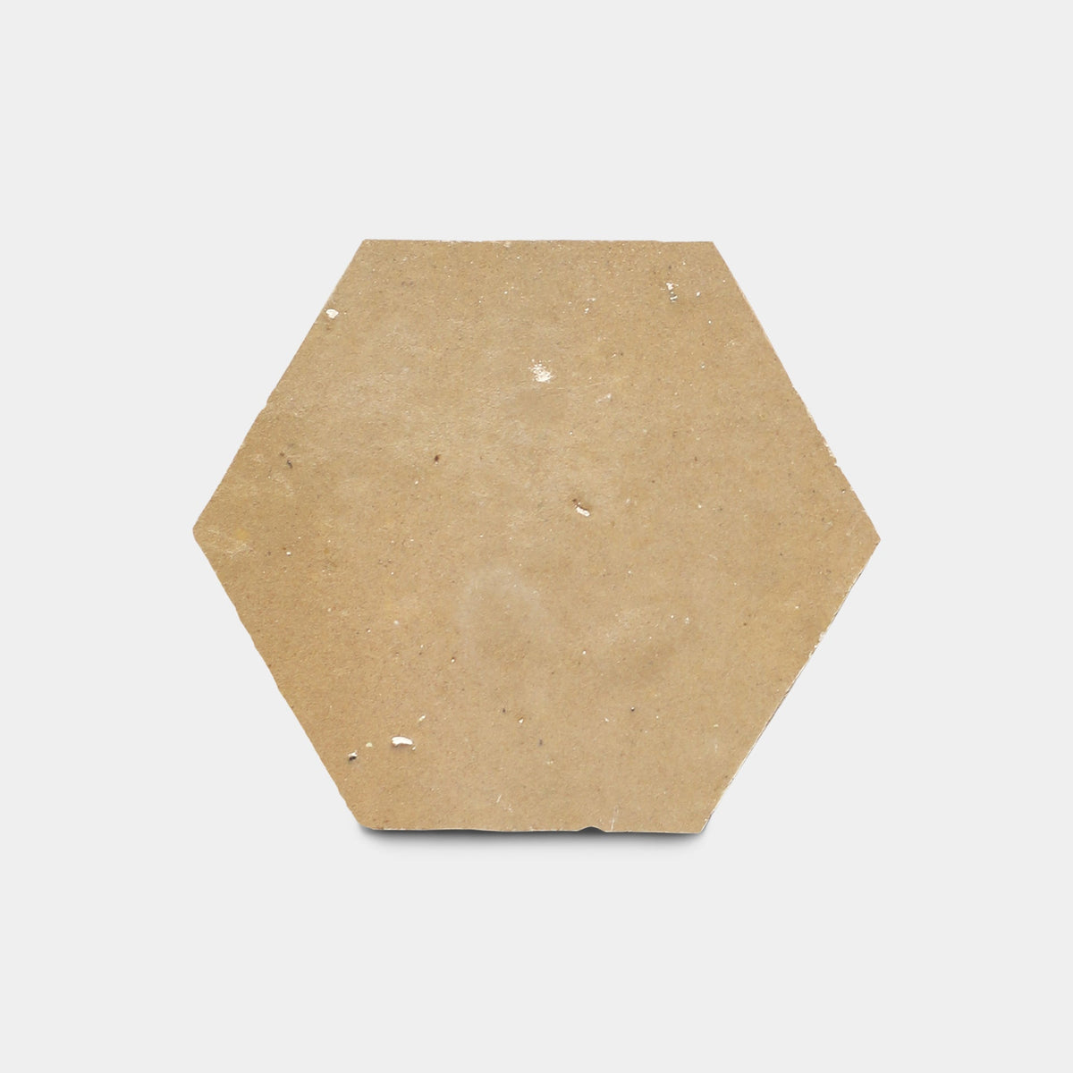 A single Glazed Earth 2x2 tile sample by Zia Tile features a rough, light brown handmade surface with slight imperfections, shown on a plain white background.
