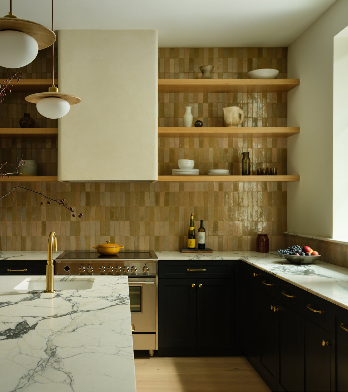 Kitchen featuring a backsplash of vertically stacked, glossy brown Glazed Earth 2x6 zellige tiles, open wood shelving, a marble-topped island, and black lower cabinets.