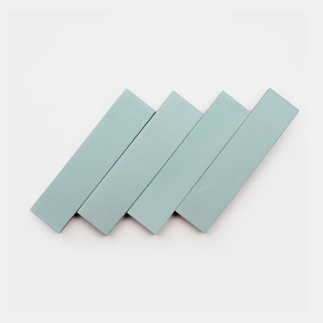 Four rectangular Hailstone 2x8 cement tiles from vendor-unknown overlap diagonally against a white background, highlighting their modern style.
