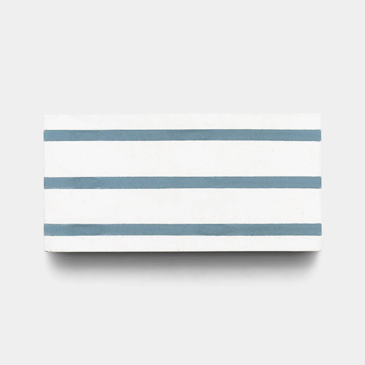 The Zia Tile High Line Hyannis 4x8 sample is a rectangular, handmade white tile with four evenly spaced horizontal blue-gray stripes on a light gray background.