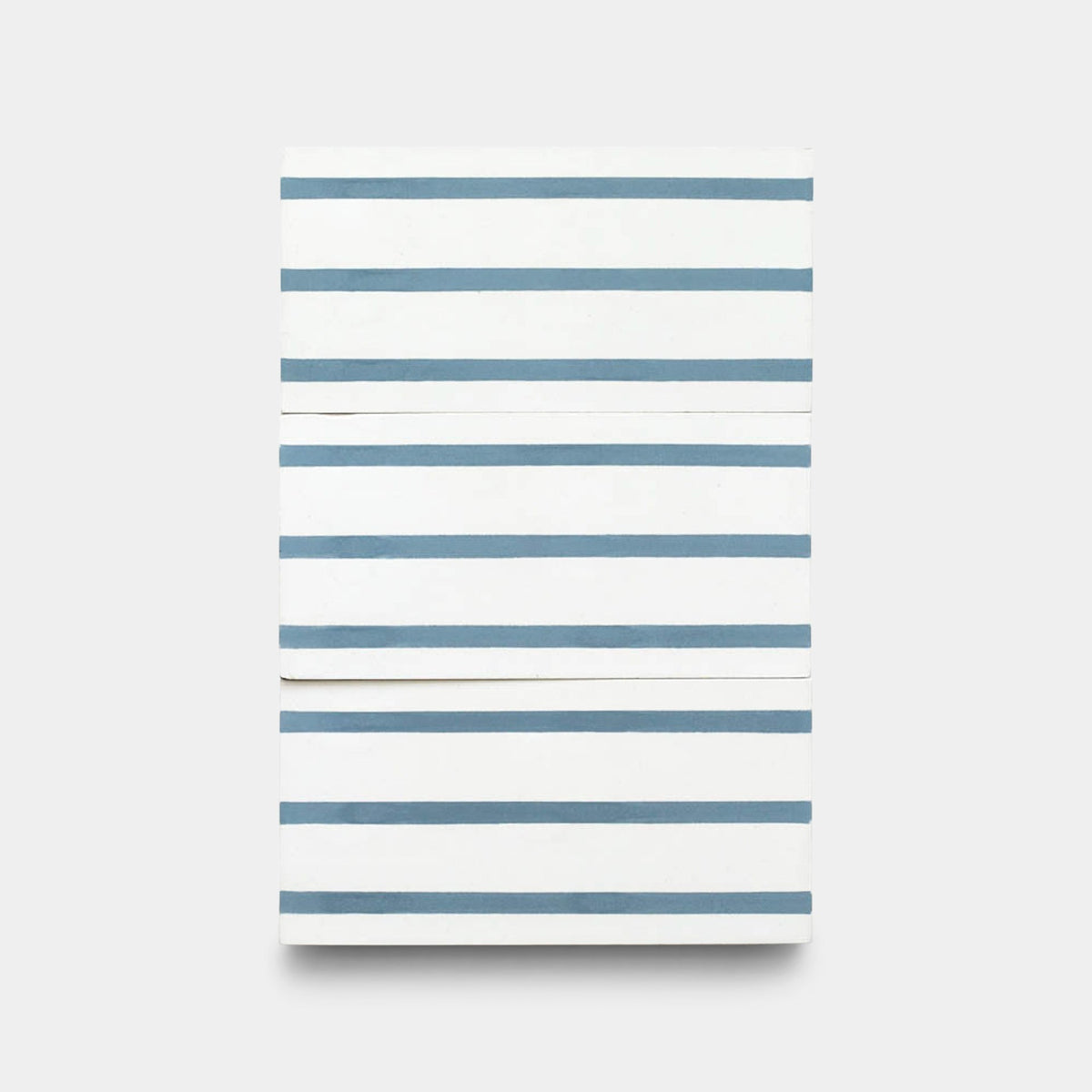 The High Line Hyannis 4x8 sample by Zia Tile features a rectangular white canvas with evenly spaced horizontal blue stripes and subtly raised textures, reminiscent of handmade tiles against a plain, light background.