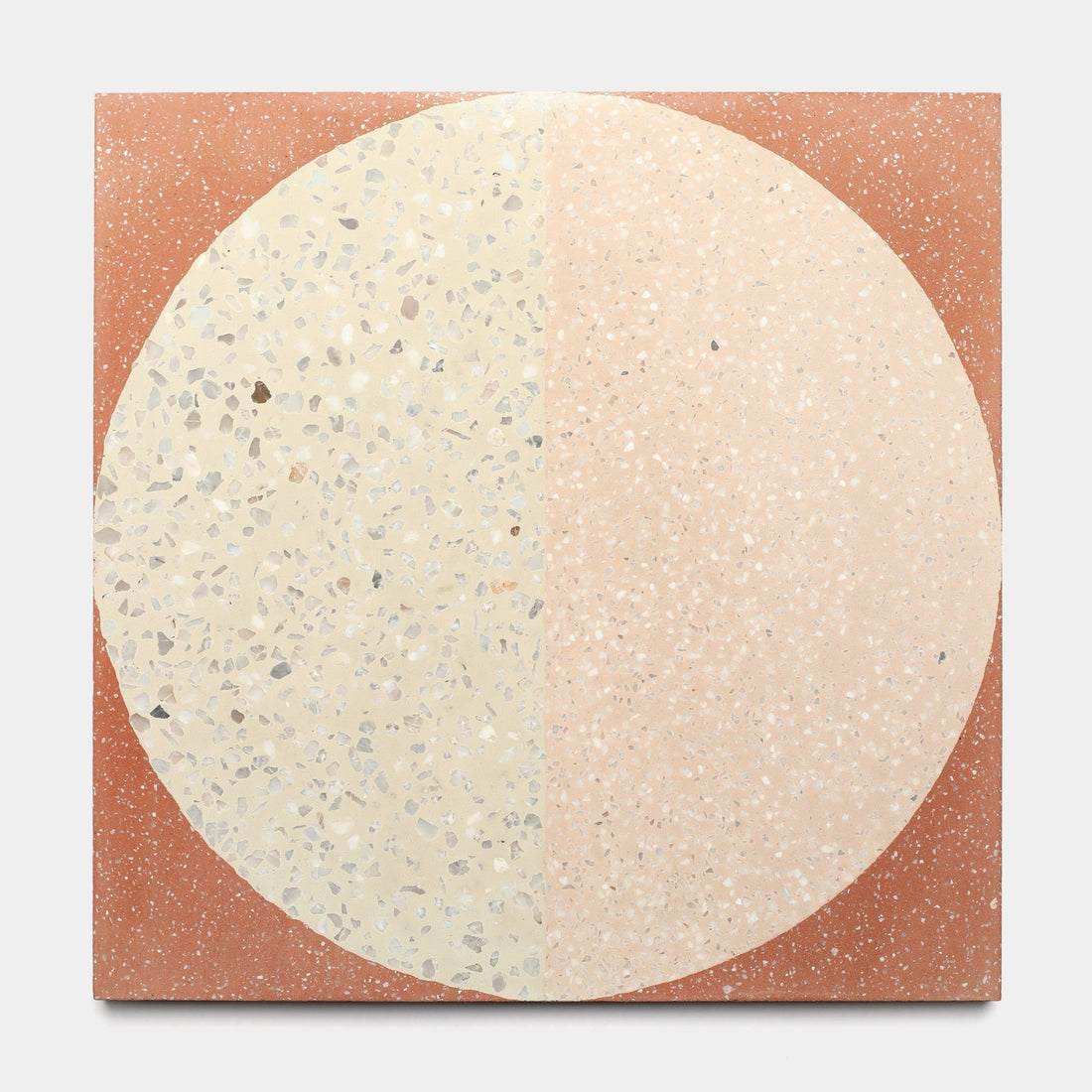 The Highball Jaipur Pink 12x12 sample by Zia Tile is a square artwork inspired by handmade tile, featuring a vertically split cream and light peach speckled circle on a reddish-brown speckled background.