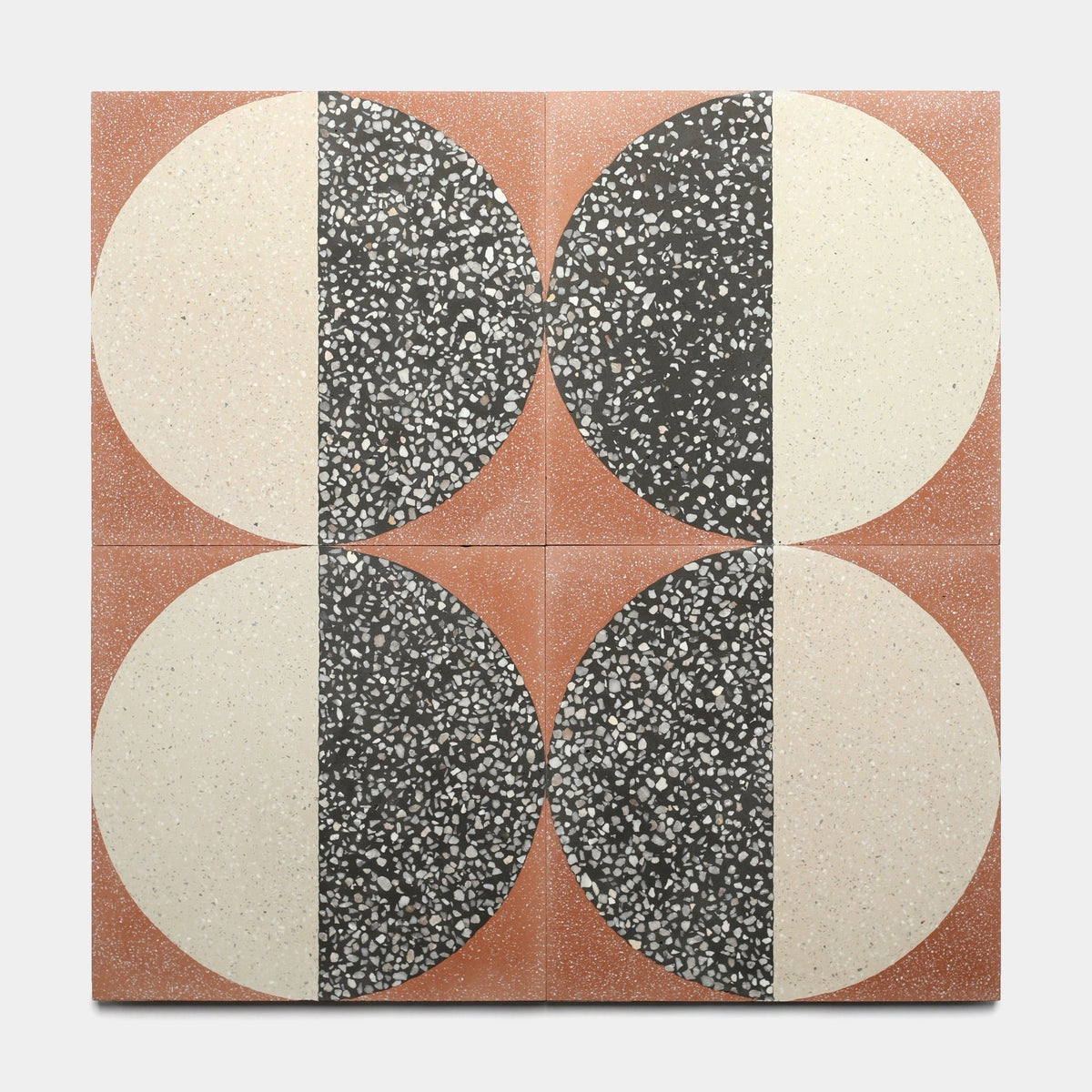 Four Zia Tile Highball Rust 12x12 tiles are arranged in a grid, each displaying a vertically split circle—one half speckled black, the other cream—against a reddish-brown background for a bold geometric effect.