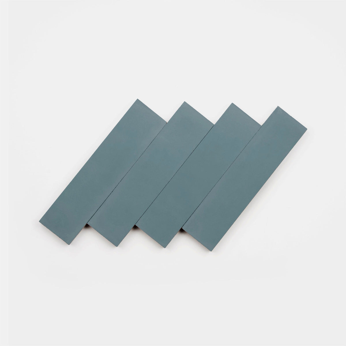 Four rectangular, flat Hyannis 2x8 tile samples by vendor-unknown in blue-gray are arranged diagonally and overlapping each other against a plain white background.