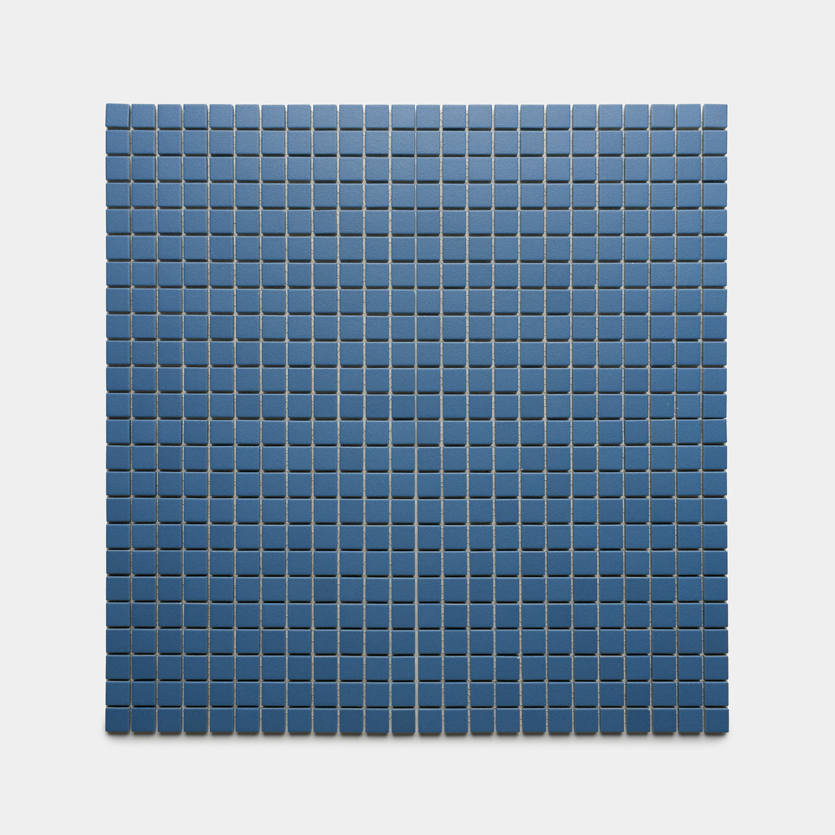 A minimalist, geometric pattern features evenly spaced Iconic Blue 1x1 tiles by Zia Tile, forming a grid of small blue squares on a plain light gray background.