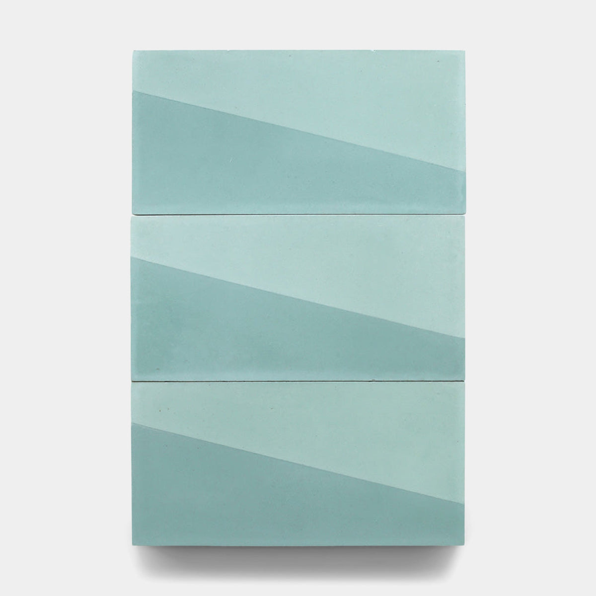 Three rectangular Incline Salvia 4x8 samples by Zia Tile in light blue and teal are arranged vertically, each with a diagonal color split forming a geometric cement tile pattern on a plain white background.