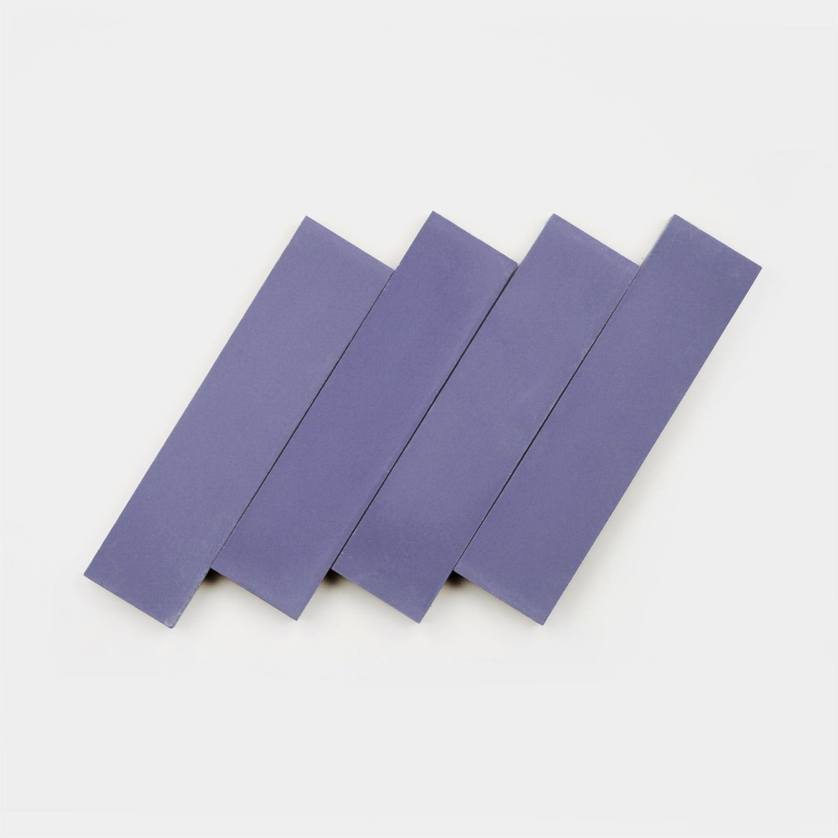 Four Indigo 2x8 tile samples from vendor-unknown, featuring a handmade look, are arranged diagonally and evenly spaced on a plain white background.