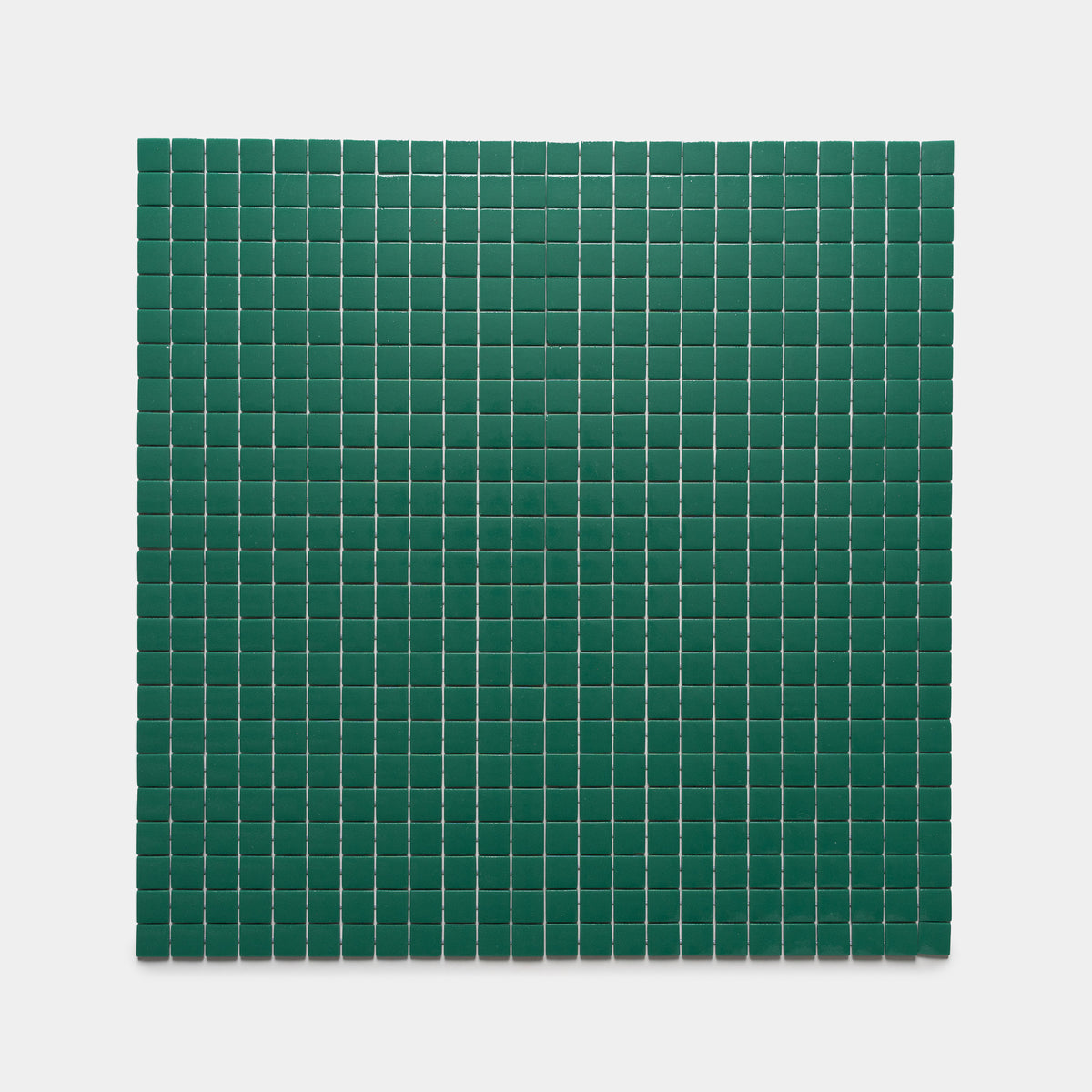 A grid of Jasper 1x1 dark green square tiles by Zia Tile is displayed, evenly spaced against a plain light gray background.
