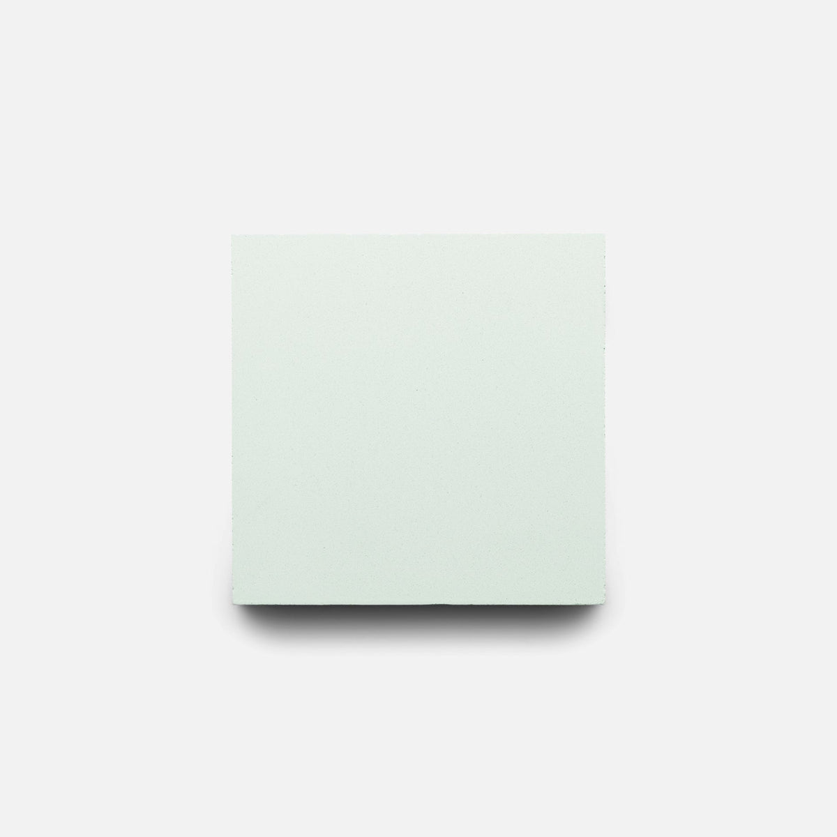 The Julep 4x4 sample tile by Zia Tile, in plain light gray cement, is centered on a white background with a subtle shadow beneath it.
