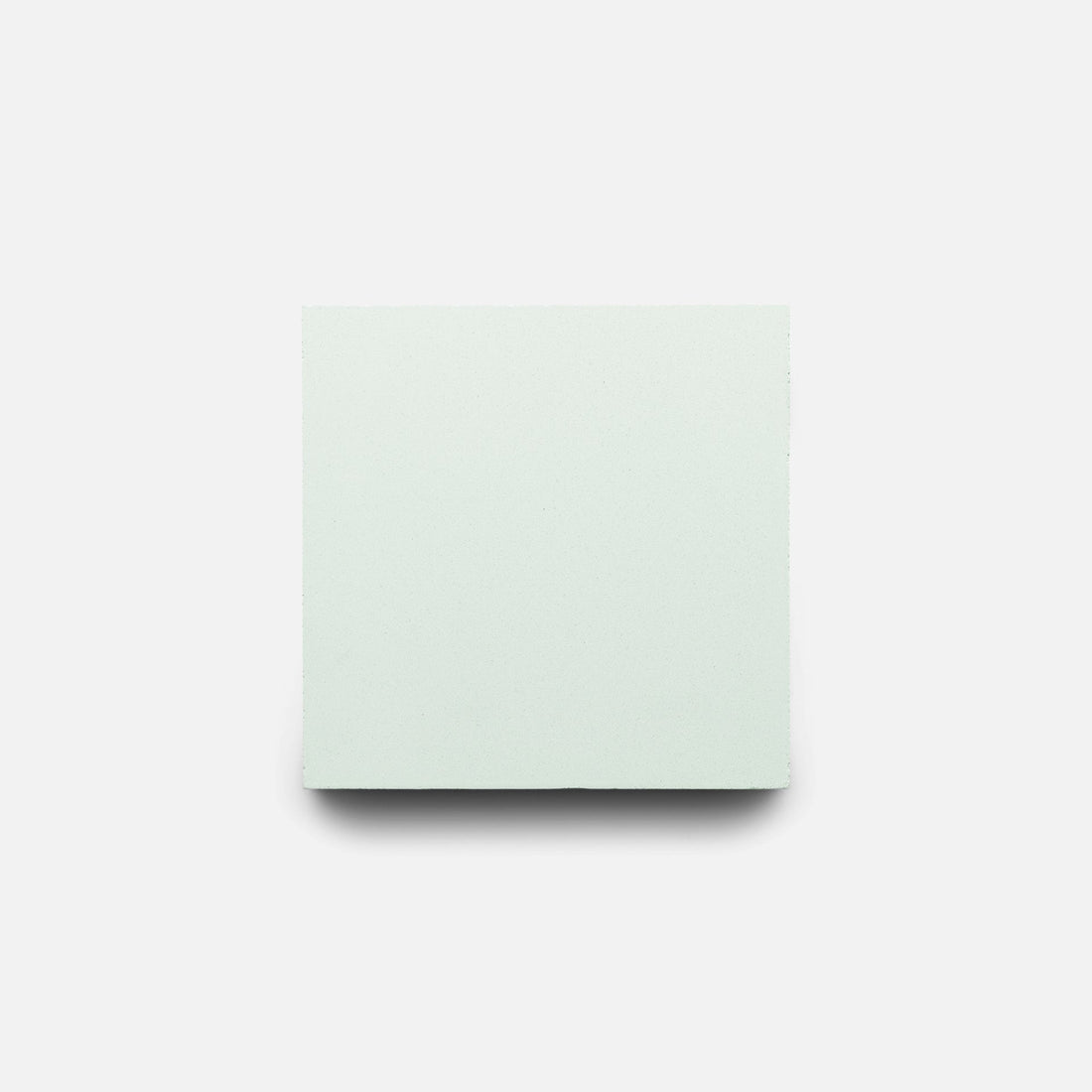 A Julep 4x4 cement tile by Zia Tile, in plain light gray, is centered on a white background with a subtle shadow beneath it.