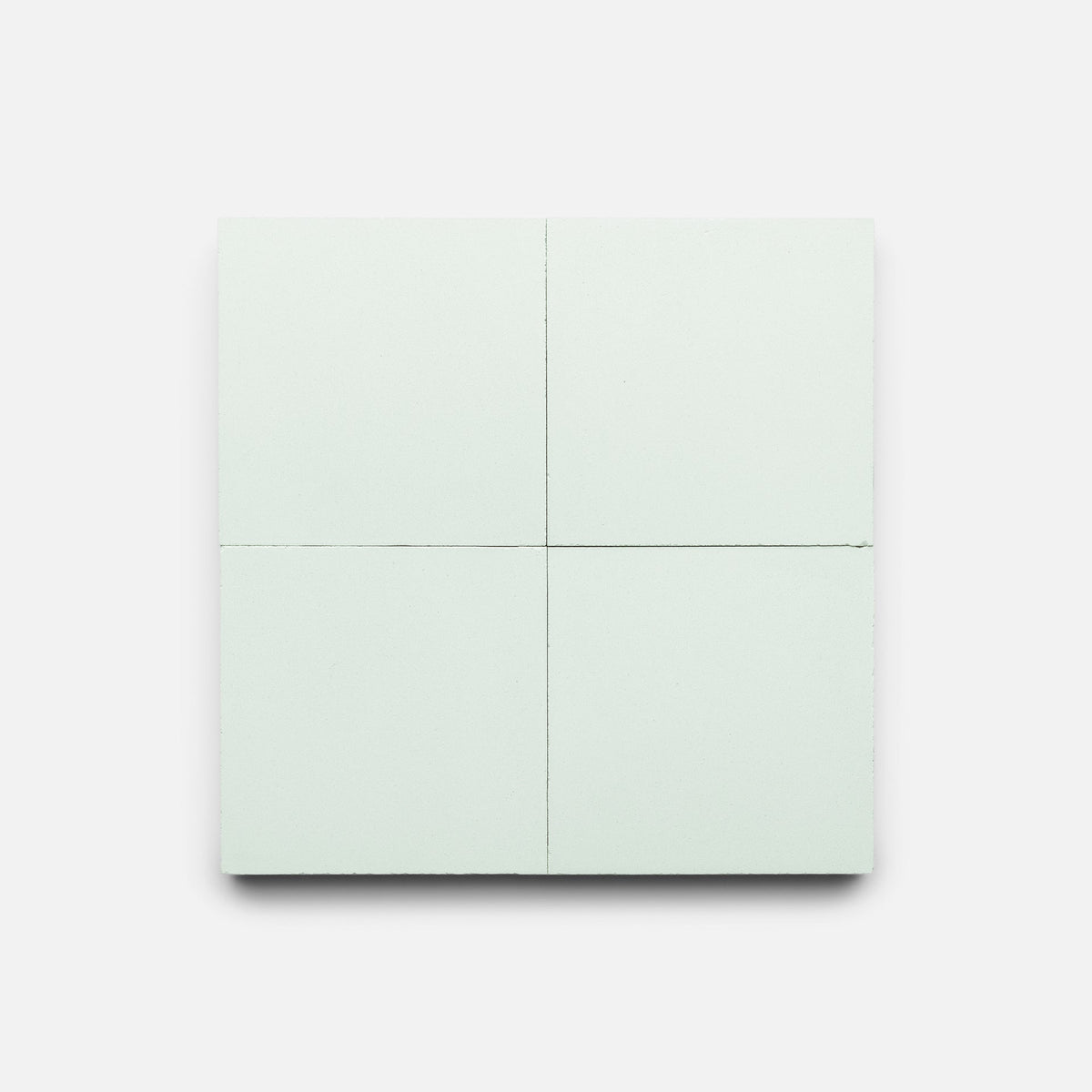 Julep 4x4 Sample by Zia Tile features a light green square, evoking handmade tile, divided into four equal sections by two perpendicular lines, all set against a plain white background.