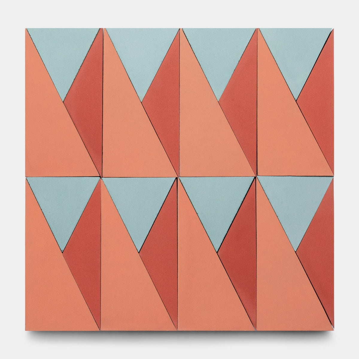 Kepler Set One Sample by Zia Tile features a modern geometric grid of alternating light blue, terracotta, and peach triangles on a light background. The abstract, repeating pattern is visually striking and inspired by classic Zia Tile cement designs.