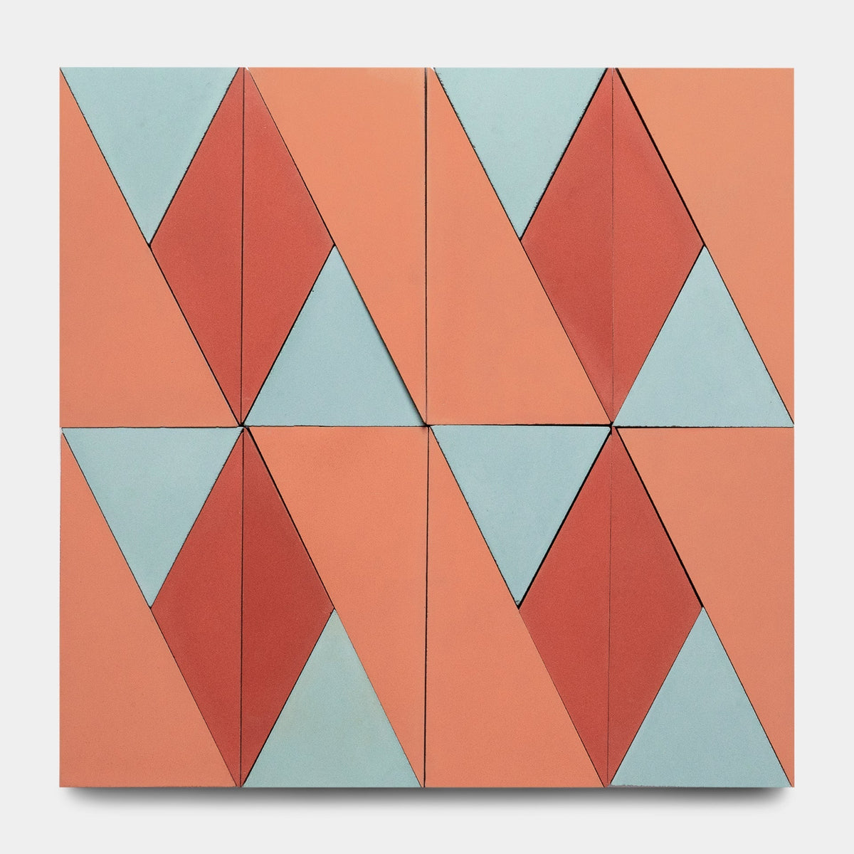 Inspired by Zia Tile’s Kepler Set One, Sample, this geometric wall art showcases a grid of red, blue, and peach triangles and diamonds reminiscent of bold abstract tile designs.