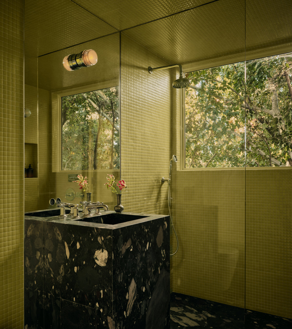 Bathroom featuring Kiwi 1x1 square tiles in light green, a black marble vanity, and a large window looking out onto trees.