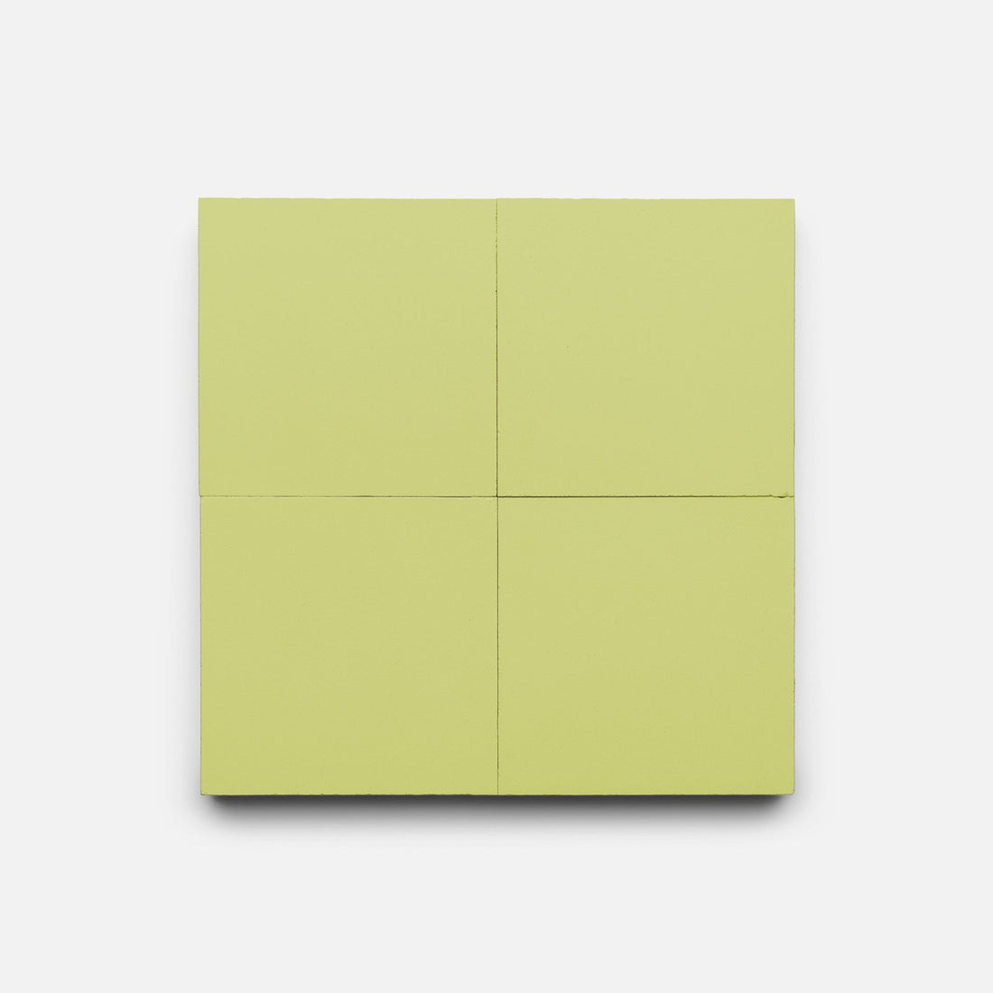 A square layout of four Lemongrass 4x4 handmade tiles from Zia Tile is set on a plain white background, subtle shadows below highlighting their light green color.