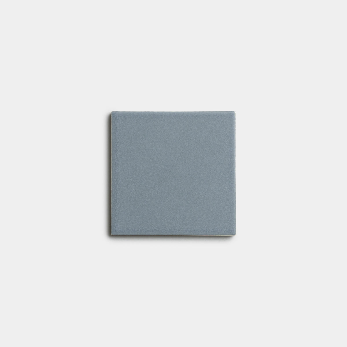 A single Loch 4x4 ceramic tile by Zia Tile, in a muted blue-gray shade and square shape, is centered on a white background.