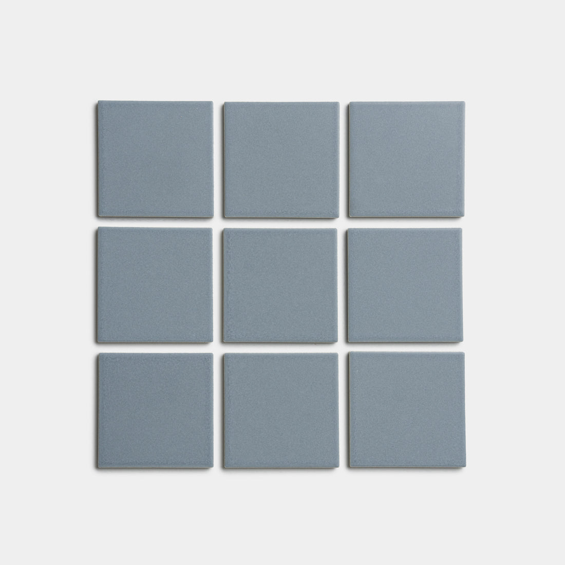 Nine evenly spaced Loch 4x4 blue-gray square tiles by Zia Tile are arranged in a 3x3 grid on a plain white background.