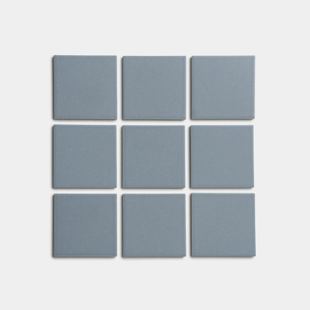 Nine evenly spaced Loch 4x4 blue-gray square tiles by Zia Tile are arranged in a 3x3 grid on a plain white background.