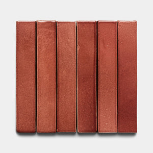 Six Lupe Mini Bar tiles by Zia Tile, rectangular and vertically aligned with a reddish-brown hue, are arranged side by side against a plain white background.