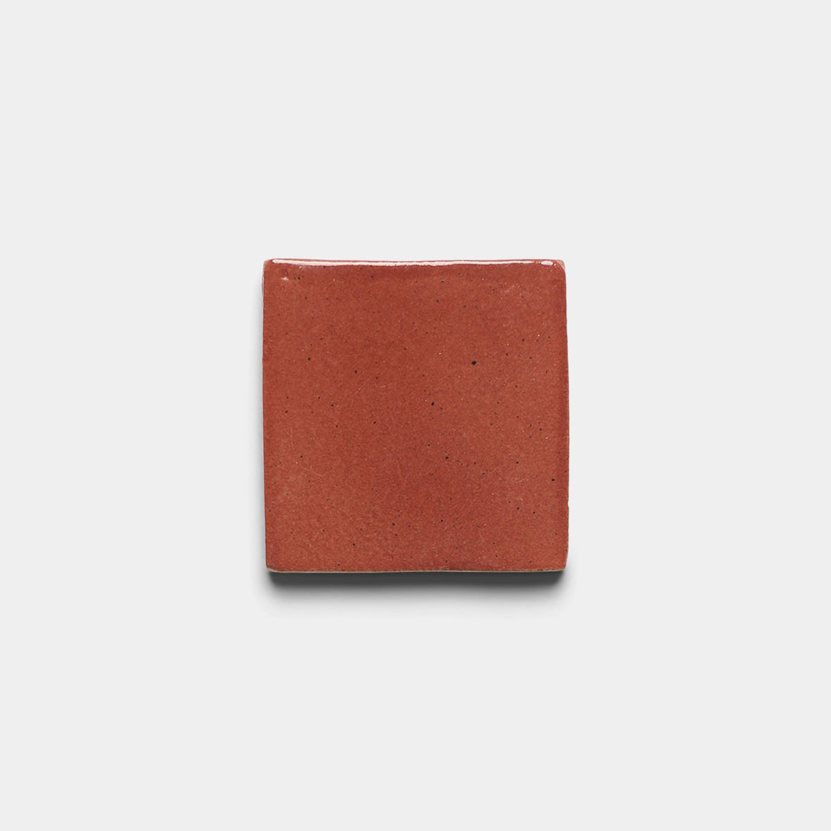 A single Lupe 4x4 Square ceramic sample tile by Zia Tile, featuring a square shape and reddish-brown, slightly glossy surface, centered on a plain white background.