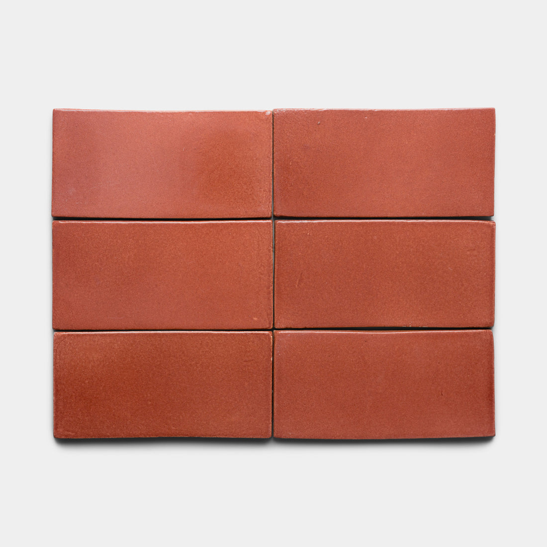 Six Lupe 4x8 Rectangle tiles by Zia Tile, featuring a reddish-brown hue and smooth matte finish, are arranged in two rows of three on a plain white background.