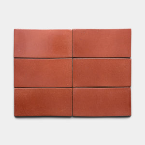 Six Lupe 4x8 Rectangle tiles by Zia Tile, featuring a reddish-brown hue and smooth matte finish, are arranged in two rows of three on a plain white background.