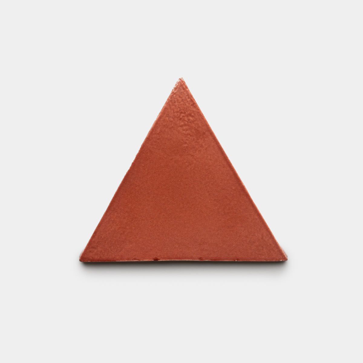 The Lupe Triangle by Zia Tile is a solid reddish-brown equilateral tile displayed centered on a plain white background.