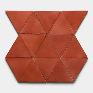 Zia Tile’s Lupe Triangle features a geometric, reddish-brown ceramic tile design that creates a symmetrical pattern of triangles and hexagons on a light gray background.