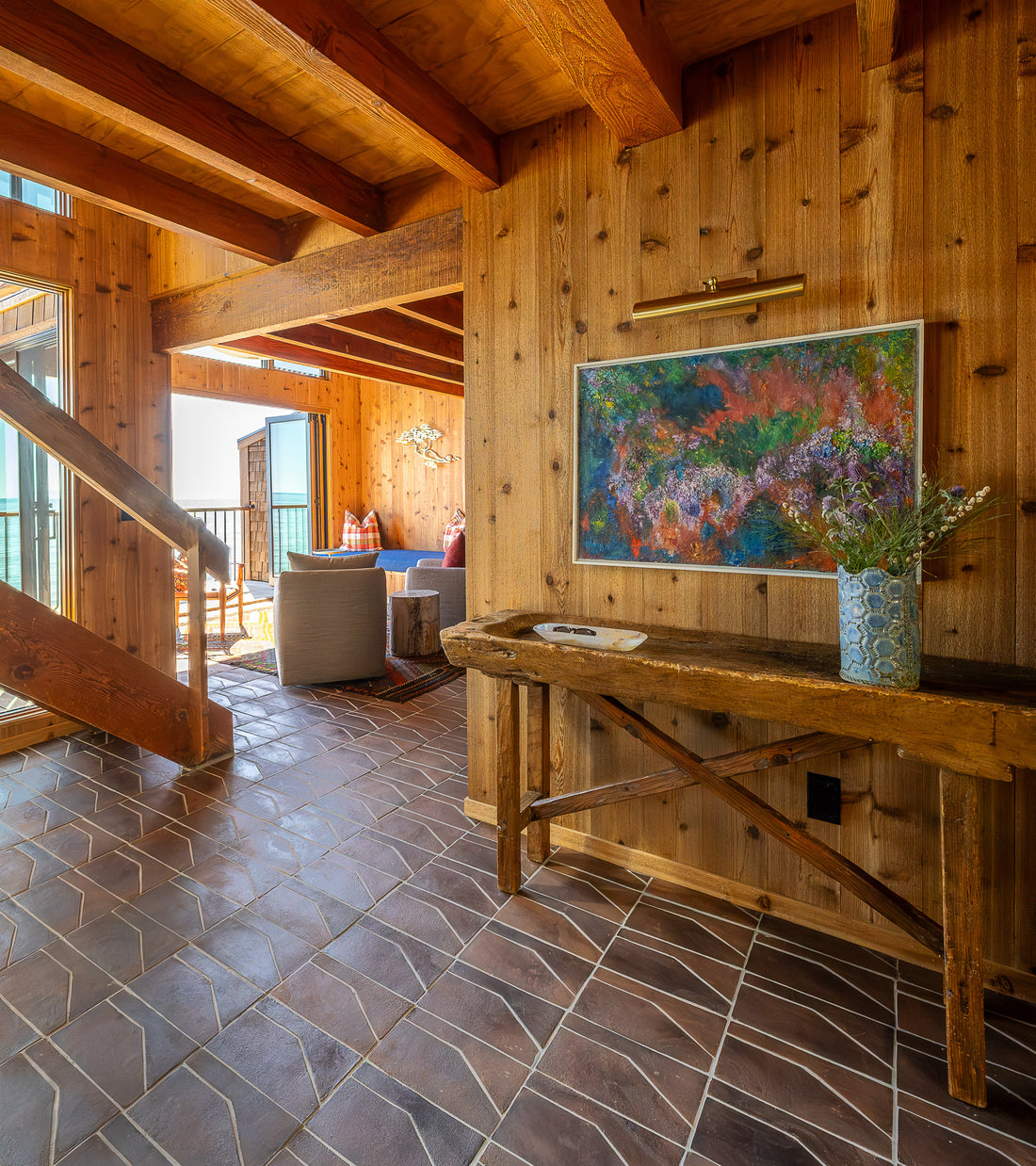 Experience the charm of San Miguel de Allende with Zocalo + Madera handmade Cotto tiles by Zia Tile—warm wood details, beams, fresh flowers, colorful art, and a bright living space complete the inviting ambiance.