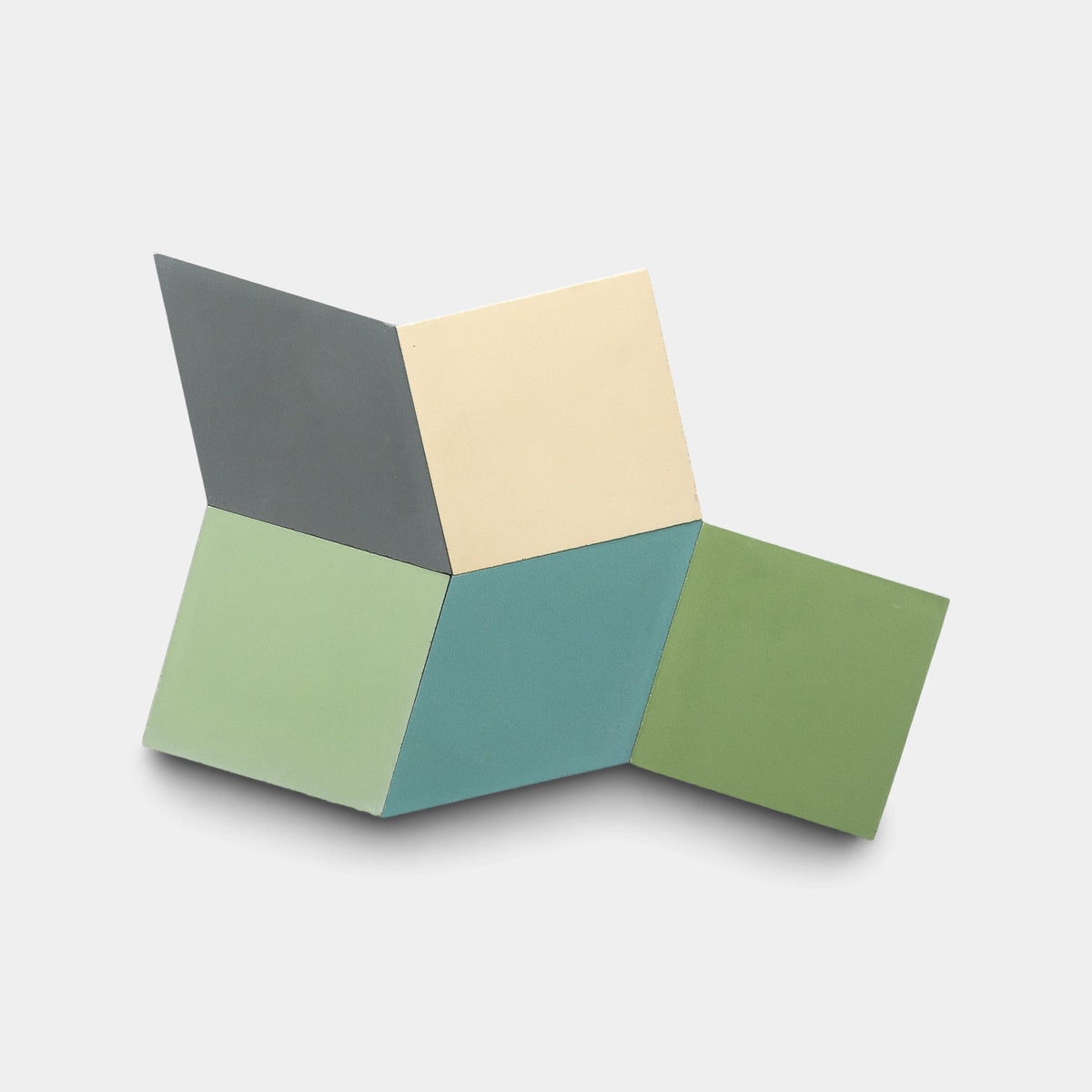 Five geometric tiles from the Madrid Set Four, Sample by Zia Tile form an abstract shape in dark gray, cream, light green, teal, and olive green—all inspired by handmade cement tile designs against a light background.