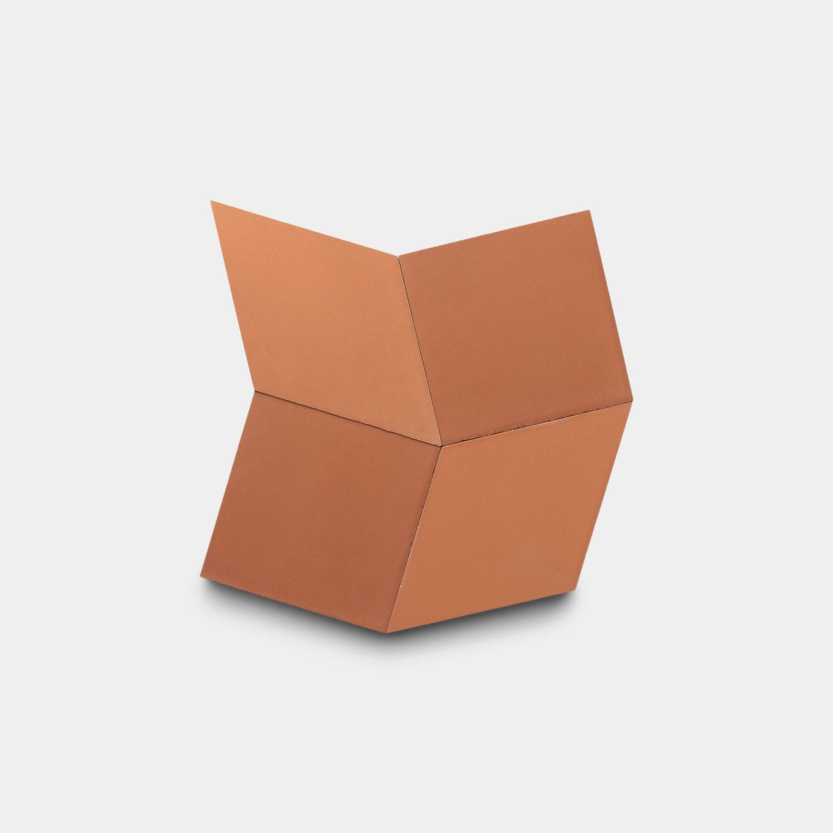The Madrid Terra Cotta + Rust, Sample by Zia Tile features four handmade, terracotta-colored square tiles joined at angles to create a three-dimensional zigzag shape, displayed against a plain white background.