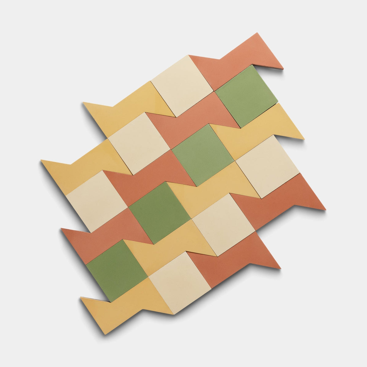 The Manolo Set Four, Sample by Zia Tile features geometric handmade tiles in cream, yellow, green, and terracotta arranged in an interlocking zigzag pattern on a white background for a signature Zia Tile look.